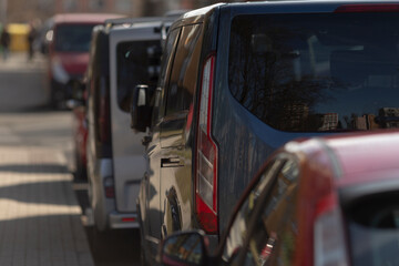 parked cars create shade scenes, long line of parked vehicles under afternoon sunlight forming...