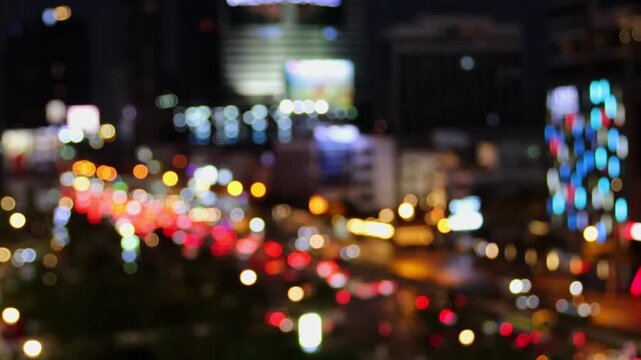Bangkok night traffic video shot using an extreme defocus to maximize the bokeh effect. Vibrant, abstract circles of red and yellow light represent rapid urban movement on the street