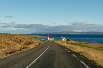 Fototapeta premium Scenic Icelandic road leading to a quaint church near the tranquil coast.