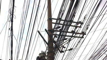 Silhouetted tangled lines appear under cloudy weather, lines contrasting sky, lines showing urban...