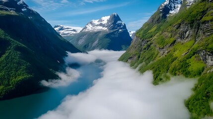 Obraz premium Majestic Mountains and Serene Misty Valley Overlooking Blue Water.