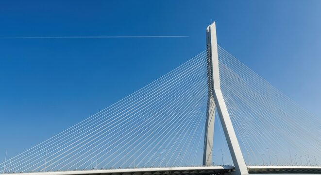 Modern cable-stayed bridge tower against a clear blue sky