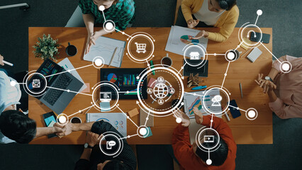 A vibrant business meeting scene depicting diverse participants collaborating over digital devices, enhanced by digital icons representing networking and strategic planning elements. Amity