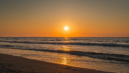 Obraz premium Sea and beach during sunrise with waves lapping at the shore, emphasizing seasonal change