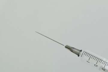 A syringe placed on a clean white background. Concept A sterile medical tool emphasizing simplicity and clarity.