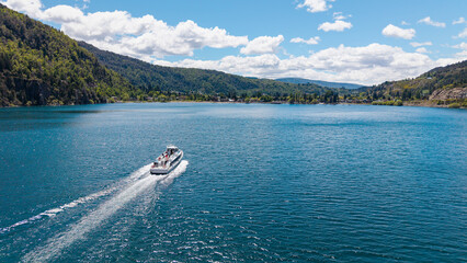 A tourist boat sails on Lake Lacar, with the city of San Martin de los Andes in the background.