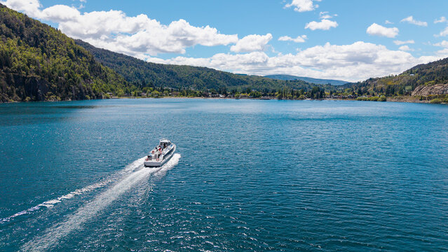 A tourist boat sails on Lake Lacar, with the city of San Martin de los Andes in the background.