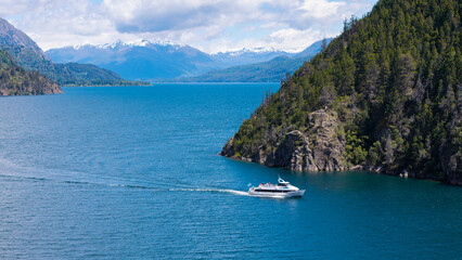 A tourist boat sails on Lake Lacar, with the Andes Mountains in the background.