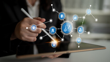 A business professional uses a tablet to engage with digital icons that represent innovative technology solutions for effective data management and commerce. Tessel