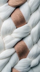 A detailed macro shot of thick, braided yarn featuring alternating strands of white and tan, highlighting the woven texture.