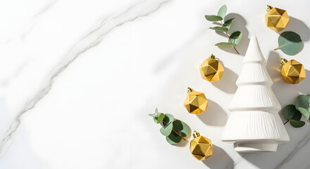 Modern Christmas flat lay with white ceramic tree, golden geometric ornaments, and eucalyptus on a marble background