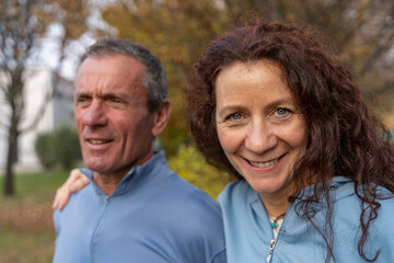 Obraz premium Smiling middle-aged woman and man sharing a moment of togetherness in nature
