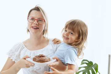 A mother giving her child a chocolate-glazed donut, an unhealthy feeding practice with food full of sugar.
