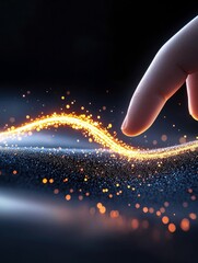 A human finger interacts with a bright, wavy trail of golden particles on a dark, textured surface, creating a sense of magic or discovery.