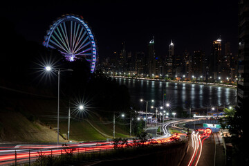 Fototapeta premium Queen's Road at night with a Ferris wheel in the background, Balneário Camboriú, Santa Catarina, Brazil