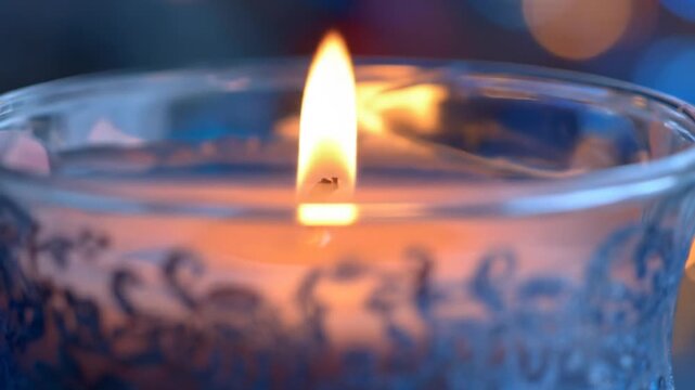 Glowing candle flame in glass jar, wax interior diffused by translucent patterns