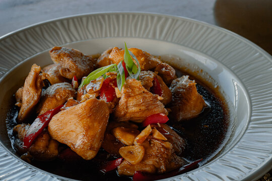 Tender chicken adobo served on a plate with savory sauce and herbs, Filipino dish