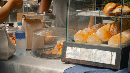 Rustic bread and pastries displayed in a bakery glass case at an outdoor market