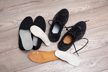 Family orthopedic insoles for adults and a child lying on the home floor and in shoes for valgus prevention and foot health