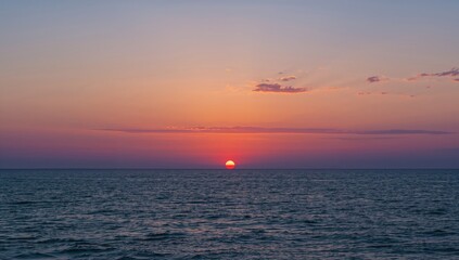 Fototapeta premium Breathtaking view of a sunset reflecting on the expansive sea, highlighting the beauty of nature's transitions