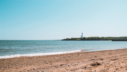 A calm beach with a distant lighthouse, ideal for relaxation and solitude