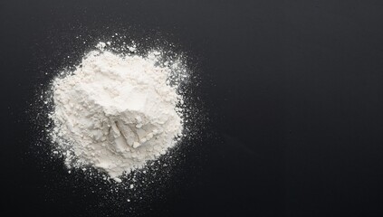 White baking flour on a black slate surface, ideal for culinary preparation and recipe development