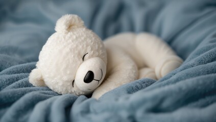 White teddy bear plush resting on a soft blue velvet blanket, promoting relaxation