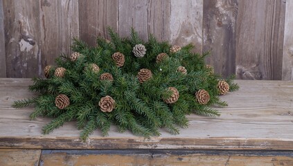 Obraz premium Christmas wreath made of pine cones and evergreen branches, seasonal decor for festive celebrations