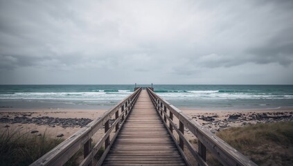 Beach scene with a pier under overcast skies, reflecting nature's unpredictability