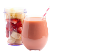 Strawberry Banana Smoothie in Clear Glass with Pink Straw Accompanied by Transparent Blender Filled with Strawberry and Banana Slices on Checkered Backdrop