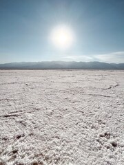 Obraz premium The sun shining over a rough salt-covered surface stretching across the dry plain.
