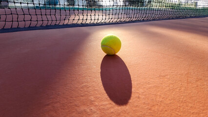 A detailed view of an empty tennis court and tennis ball.