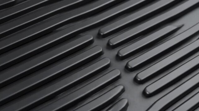 A close-up view presents a gray-toned, textured surface featuring elevated, parallel lines and curved edges