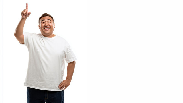 Happy plus size Asian man in plain white t-shirt and jeans, with pointing up pose, isolated on a clean white background.