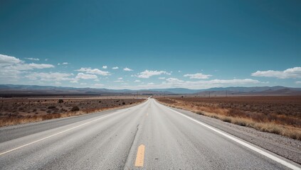 Fototapeta premium Long stretch of white asphalt against a blue landscape, potential for summer road trips