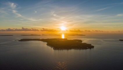 Fototapeta premium Golden sunset illuminating tropical islands with silhouettes, highlighting seasonal change