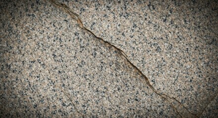 Close-up of speckled stone surface with a diagonal fracture