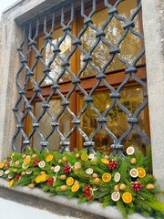 Christmas garland of pine needles and dried fruits on the window