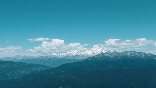A breathtaking view reveals majestic snow-capped mountains under a clear blue sky, emphasizing natural beauty and tranquility.
