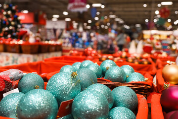 Christmas toys, turquoise balls in baskets on blurred festive lights background. New Year...