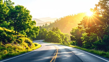 Scenic Winding Asphalt Road Through Lush Green Forested Mountains Under a Bright Golden Sunburst Lighting the Landscape