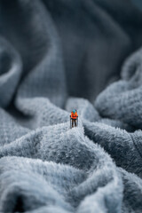 A mountaineer figurine on a fluffy fleece fabric that looks like a snow-covered mountain surface