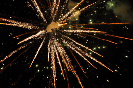 Burst of golden fireworks against a dark night sky, captured at the peak of the explosion. Ideal for themes of celebration, holiday events and festive backgrounds.