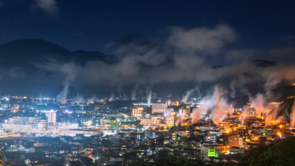 Beppu city with motion steam of hot spring and stars at night , Oita