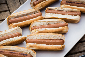 a plate of hot dogs is seen at a local outdoor party