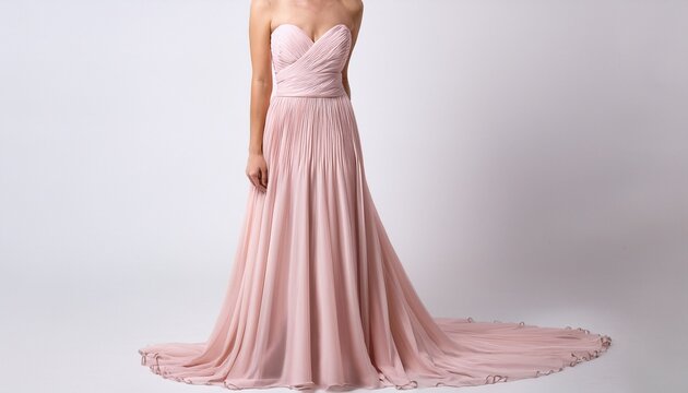 a light pink strapless evening gown with a high slit standing against a white background