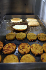 hamburguesas vegetales y ecológicas friéndose a la plancha con panecillos de brioche