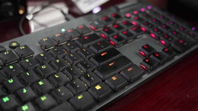 Close up of RGB computer keyboard with realistic dust on keys on desk 4K