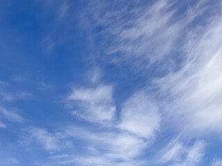 Feathery Cirrus Clouds Sweeping across Clear Blue Sky
