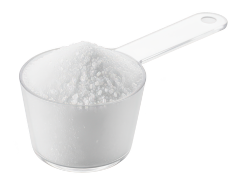 Close-up of a white measuring scoop filled with granular white powder, suitable for culinary, baking, or laboratory use, isolated on a plain